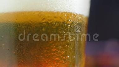 宏观拍摄的一个啤酒杯与冷啤酒，气泡上升的玻璃。 慢动作啤酒气泡..